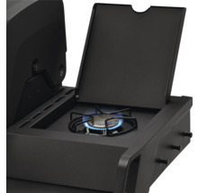 Brûleur latéral d'un barbecue à gaz noir avec flamme allumée et couvercle ouvert.