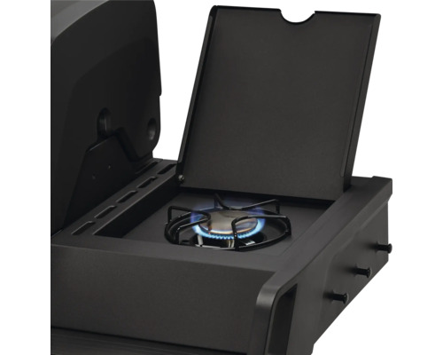 Brûleur latéral d'un barbecue à gaz noir avec flamme allumée et couvercle ouvert.