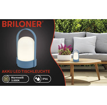 Briloner Logo, lampe de table LED à batterie pour extérieur, lumière blanc chaud 3000 Kelvin, protection IP44, portable avec poignée sur une table.