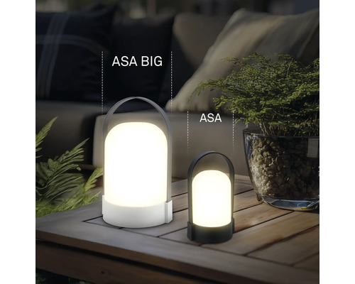 Deux lampes de table à LED portables ASA BIG et ASA de tailles différentes sur une table en bois à l'extérieur avec des plantes et des coussins.