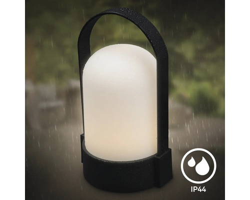 Lanterne extérieure portable avec poignée, indice de protection IP44 contre les projections d’eau, présentée sous la pluie.