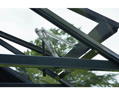 Automatischer Fensteröffner aus Metall für Gewächshäuser mit Federmechanismus montiert an einem schwarzen Dachfenster.