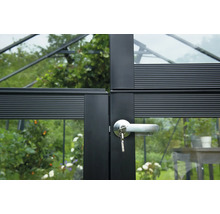 Detailansicht eines schwarzen Gewächshaustürrahmens mit einem silbernen Türgriff und einem steckenden Schlüssel.