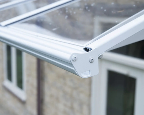 Détail d'un toit de terrasse blanc en aluminium avec des panneaux transparents.