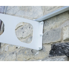 Support métallique blanc pour un auvent, monté sur un mur en pierre naturelle avec des vis apparentes.