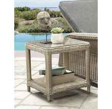 Quadratischer Beistelltisch aus Polyrattan mit Glasplatte und Ablagefläche auf einer hellen Terrasse am Pool neben einer Gartenliege.