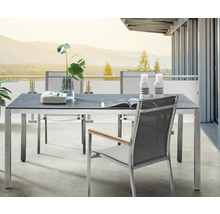 Ensemble de jardin moderne sur balcon avec table rectangulaire, plateau gris foncé, cadre en métal et chaises en maille avec accoudoirs en bois.