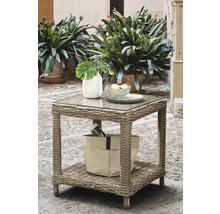 Table d appoint de jardin carrée en polyrotin gris avec plateau en verre et étagère de rangement, décorée d un vase et d un bol sur une terrasse.