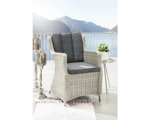 Fauteuil de jardin en résine tressée gris clair avec coussins anthracite sur une terrasse avec vue sur le lac.