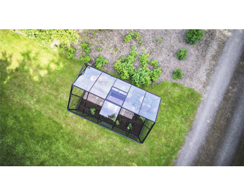 Vue de dessus d une serre rectangulaire avec cadre métallique et panneaux en verre sur une pelouse dans un jardin.