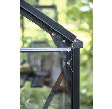 Gros plan d'un raccord d'angle sur le cadre d'une serre en aluminium noir avec des vitres et des vis de fixation.