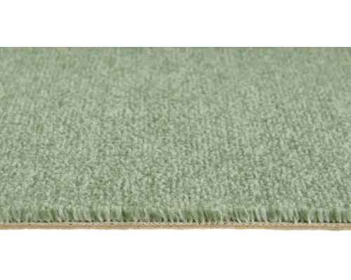 Nahaufnahme eines weichen grünen Teppichbodens mit dichtem Flor und sichtbarem Rücken.