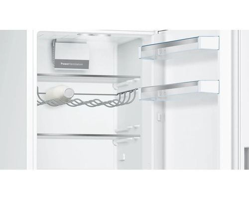 Intérieur du réfrigérateur avec système PowerVentilation, porte-bouteilles en métal avec une bouteille et clayettes en verre aux profilés argentés.