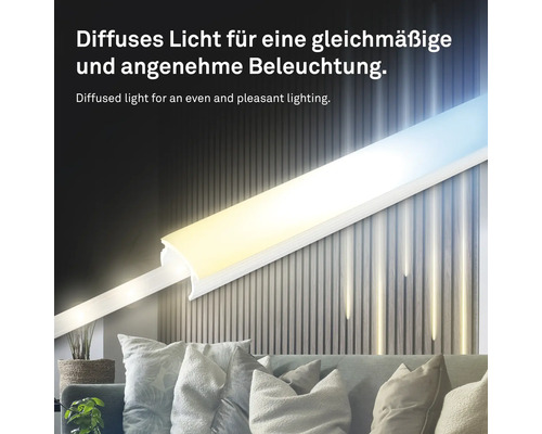 LED-Profil mit Diffusor sorgt für gleichmäßiges Licht an einer Holzpaneelwand über einem Sofa mit Kissen.
