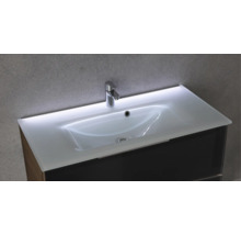 Lavabo en verre avec éclairage LED intégré, robinetterie chromée et meuble sous-vasque sombre.