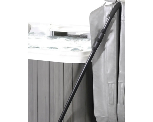 Whirlpool Abdeckungslifter aus schwarzem Metall an einem grauen Whirlpool mit gefalteter Abdeckung.