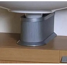 Cache-siphon en plastique avec surface rainurée sous un lavabo sur un meuble sous-vasque.