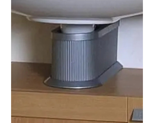 Cache-siphon en plastique avec surface rainurée sous un lavabo sur un meuble sous-vasque.