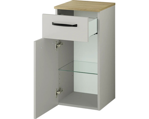 Meuble bas de salle de bain avec un tiroir et une porte, comprenant une étagère en verre et un plateau supérieur aspect bois.