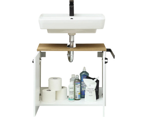 Meuble de lavabo avec vasque blanche, robinetterie noire, étagère en bois et meuble bas ouvert avec papier toilette et produits de nettoyage.