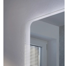 Gros plan d'un miroir de salle de bain avec éclairage LED intégré et coins arrondis.