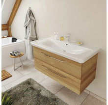 Meuble sous-lavabo moderne suspendu en aspect bois avec une large vasque blanche et des poignées chromées.