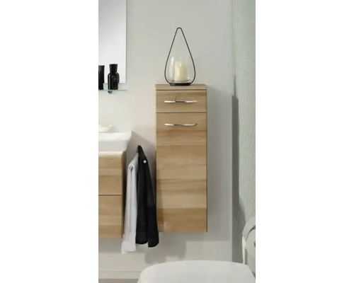 Armoire latérale de salle de bains moderne suspendue en aspect bois avec un tiroir, une porte et des poignées chromées.