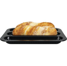 Baguette-Backform für drei Baguettes, gelocht, mit zwei fertig gebackenen Baguettes.