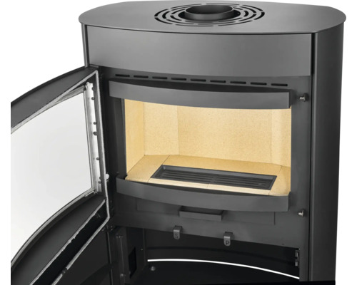 Poêle à bois noir avec porte ouverte, chambre de combustion avec briques réfractaires et grille, raccordement de fumée sur le dessus.