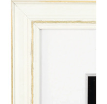 Nahaufnahme eines weissen Bilderrahmens aus Holz im Shabby-Chic-Stil mit goldenen Akzenten und weissem Passepartout.