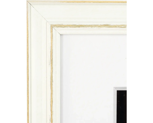Nahaufnahme eines weissen Bilderrahmens aus Holz im Shabby-Chic-Stil mit goldenen Akzenten und weissem Passepartout.