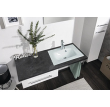 Helles Badezimmer mit weissem Unterschrank, dunkler Arbeitsplatte in Steinoptik und integriertem weissem Waschbecken mit verchromter Armatur.