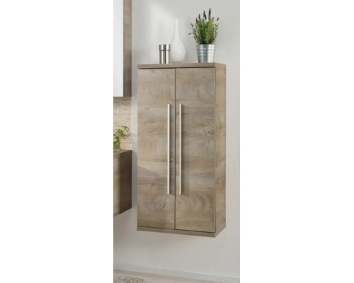Armoire de salle de bain murale aspect bois avec deux portes et de longues poignées argentées dans une pièce lumineuse.