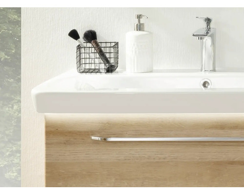 Meuble sous-vasque moderne avec vasque blanche, robinet chromé, distributeur de savon et meuble aspect bois avec éclairage LED.