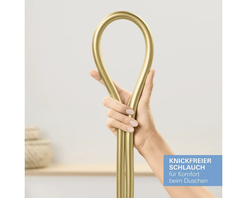 Eine Hand hält einen flexiblen, goldfarbenen Brauseschlauch, um die knickfreie Eigenschaft zu demonstrieren.