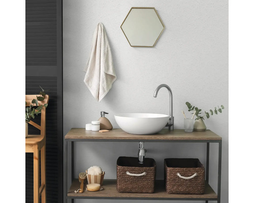 Modernes Badezimmer mit weissem Aufsatzwaschbecken, hohem Wasserhahn, sechseckigem Spiegel und Holz-Waschtisch mit Aufbewahrungskörben.