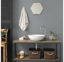 Modernes Badezimmer mit weißem Aufsatzwaschbecken auf einem Holzunterschrank, hohem Wasserhahn, sechseckigem Spiegel und geflochtenen Körben.