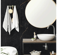 Modernes Badezimmer mit Wandfliesen in schwarzer Marmor-Optik, rundem Spiegel und weißem Aufsatzwaschbecken auf einer Holzkonsole.