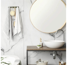 Salle de bains lumineuse avec mur en marbre blanc, miroir rond, vasque à poser en céramique blanche sur console en bois et robinet chromé.