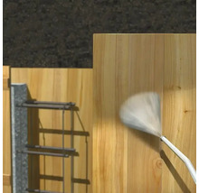 Pulvérisation d'une surface en bois avec une buse de pulvérisation pour la protection ou l'entretien.