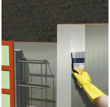 Application d'un apprêt au pinceau sur une surface murale dans le domaine de la construction.