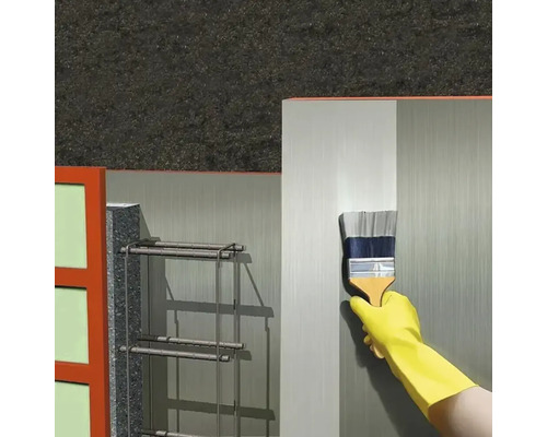 Application d'un apprêt au pinceau sur une surface murale dans le domaine de la construction.