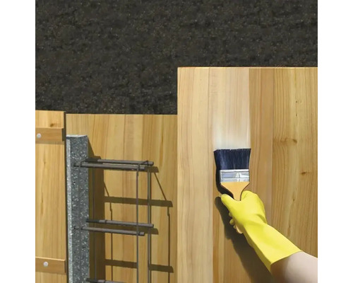 Une main gantée applique un produit de protection pour le bois à l'aide d'un pinceau sur une planche en bois.