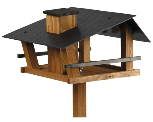 Vogelhaus aus Holz mit dunklem Dach, Schornstein und Pfosten zur Fütterung von Vögeln.
