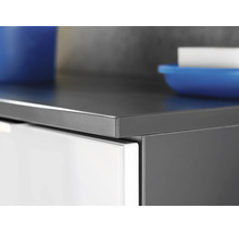 Vue détaillée du chant d'un plan de travail de cuisine anthracite sur un meuble bas blanc.
