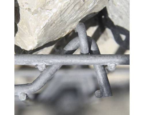 Nahaufnahme eines Gabionendrahtgeflechts mit Steinen. Fokus auf die ineinandergreifenden Metalldrähte und Haken des verzinkten Stahlkorbs.