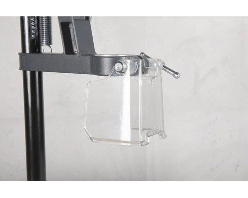 Protection transparente contre les copeaux sur un support de perceuse en métal.