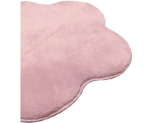 Tapis en peluche douce rose de forme nuage irrégulière avec bordure surjetée.