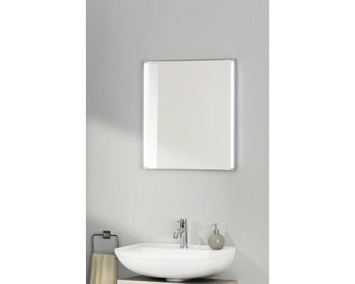 Miroir de salle de bain rectangulaire avec bandes LED latérales au-dessus d'un lavabo blanc avec robinet chromé.
