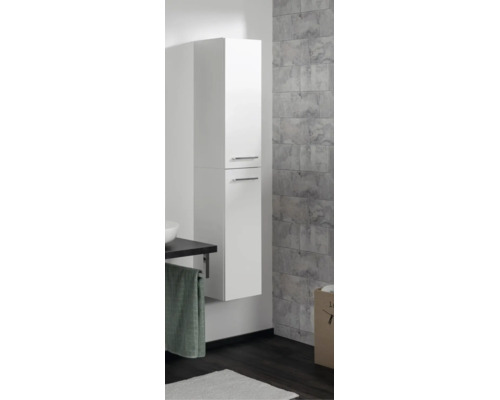 Colonne de salle de bains blanche suspendue avec deux portes et poignées argentées dans une salle de bains moderne.